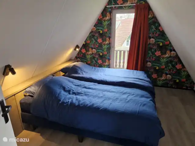 Maison de luxe 'De Boskant' | Pays-Bas, Overijssel, Gramsbergen - maison de vacances La chambre principale de la maison est située à l'étage et dispose d'un balcon privé donnant sur le jardin. La chambre offre suffisamment d'espace pour un couchage supplémentaire pour un petit enfant dans le lit de camping. Les 2 lits avec sommier à ressorts autonomes peuvent également être séparés.