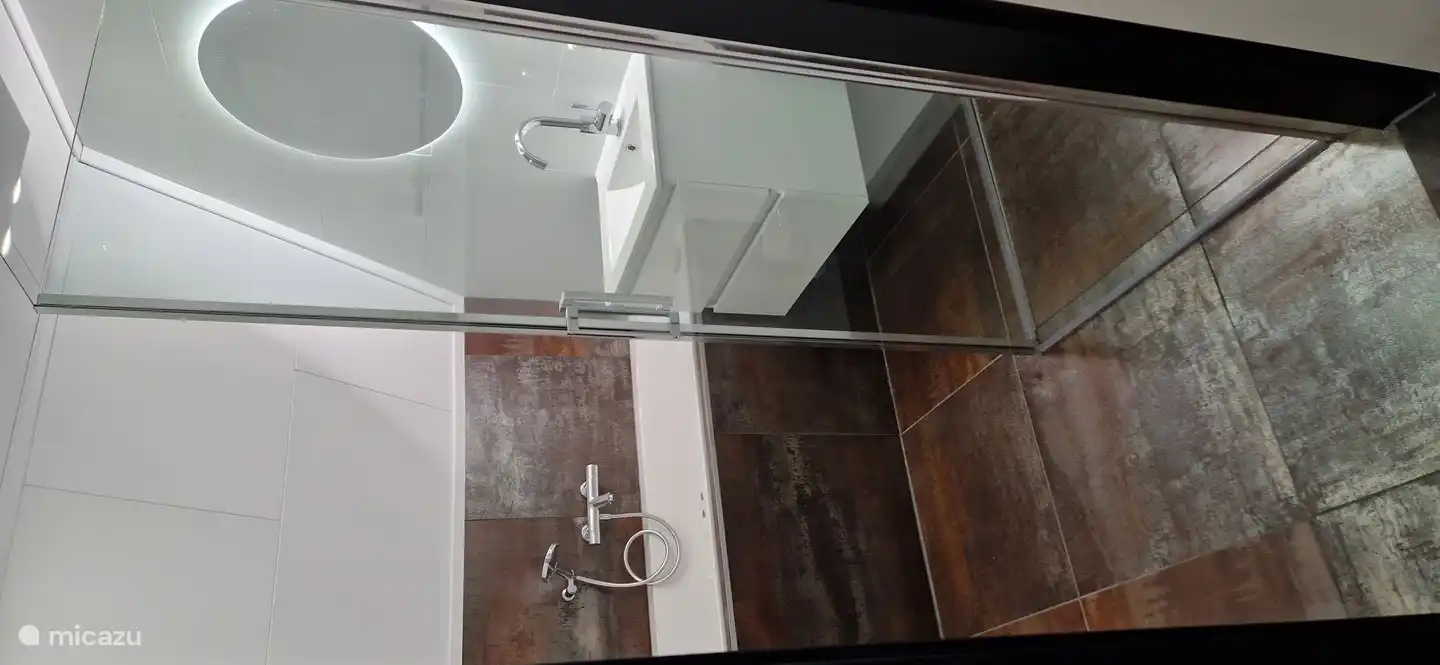 Cuarto de baño con una maravillosa ducha de efecto lluvia, bañera con hidromasaje, calefacción por suelo radiante y lavabo.