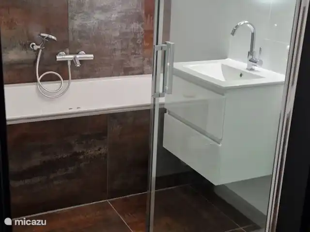 Maison de luxe 'De Boskant' | Pays-Bas, Overijssel, Gramsbergen - maison de vacances Salle de bain avec une magnifique douche à effet pluie, une baignoire avec bain à remous, un chauffage au sol et un lavabo.