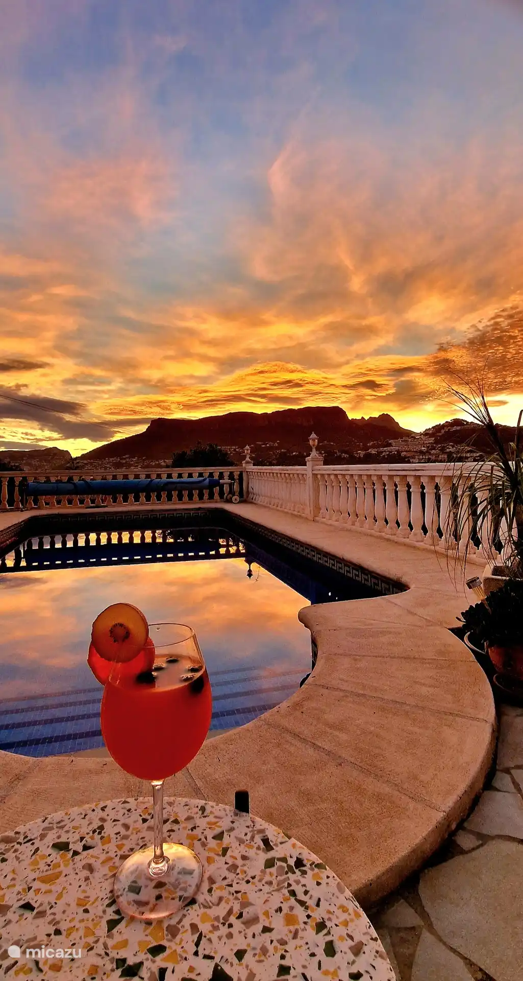 Genießen Sie den glückseligen Sonnenuntergang bei einem leckeren Cocktail 