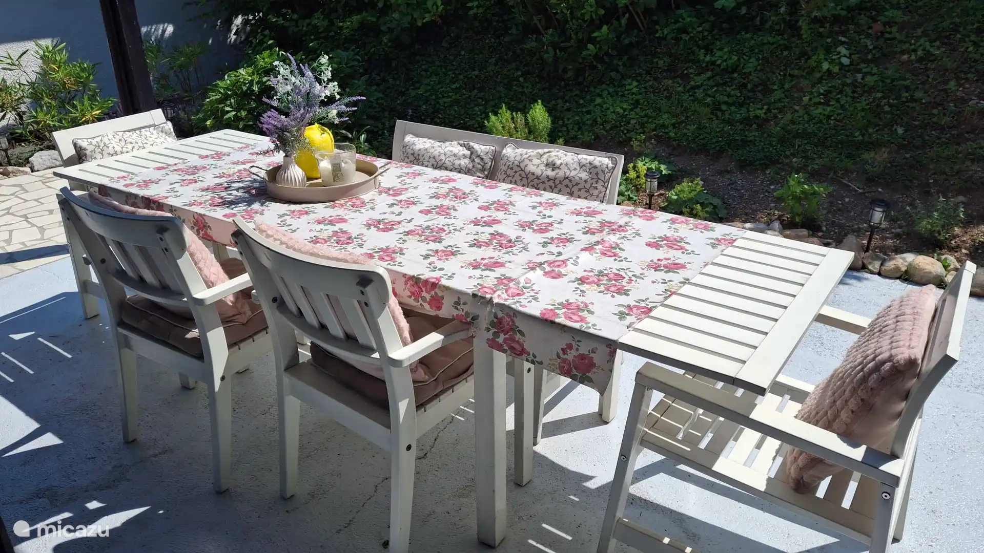 Grote eettafel onder de overkapping aan de achterzijde van de bungalow