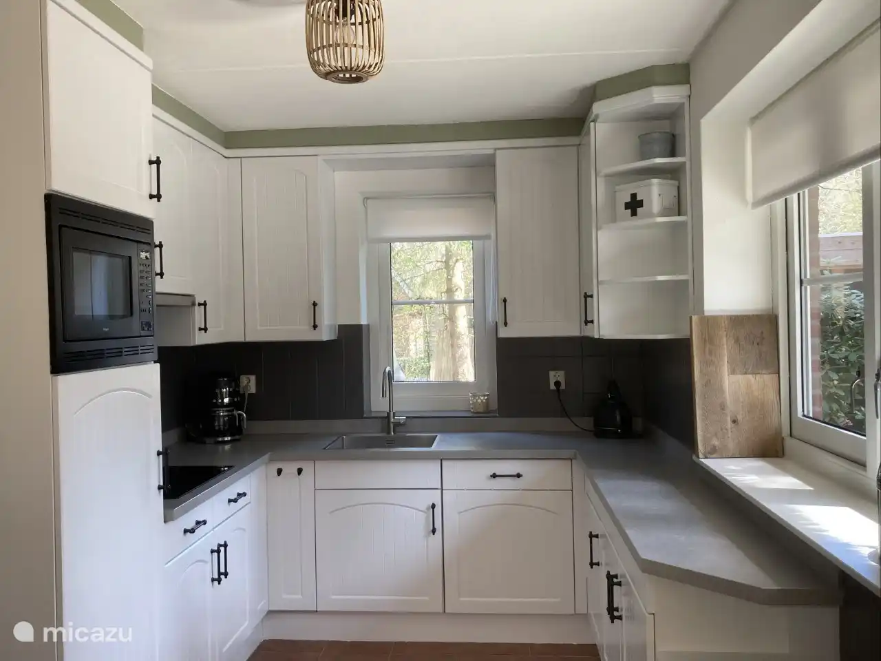 Keuken met inductiekookplaat, vaatwasser en combimagnetron.