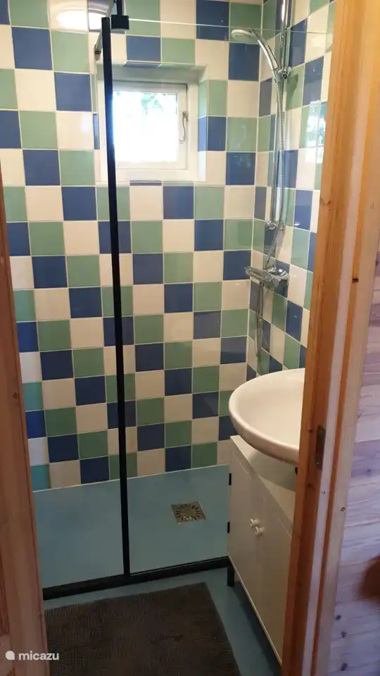 Das Badezimmer mit Dusche und Waschbecken.