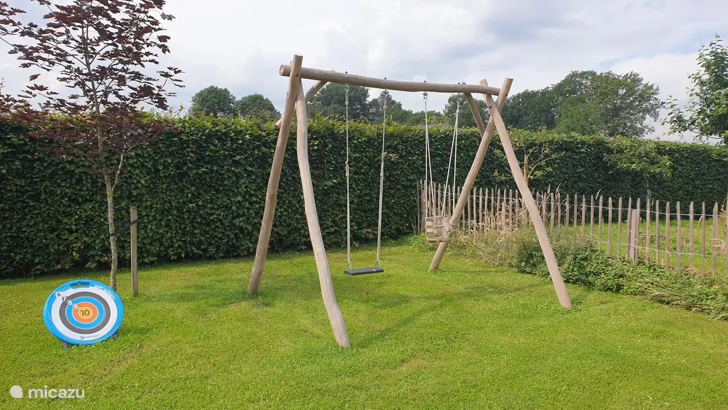 Neben dem Trampolin und der Sprungstange gibt es eine Schaukel für die Kinder.