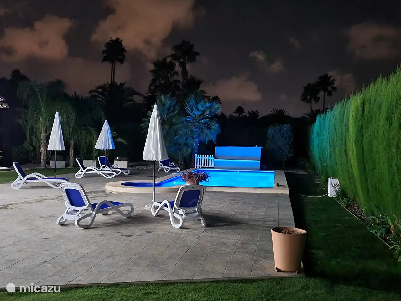 Nachtfoto van het zwembad en huis.