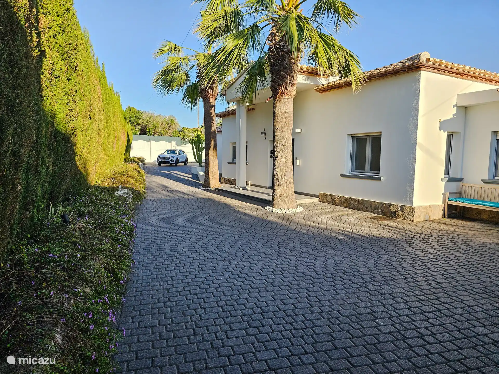 Oprijlaan naar overkapping voor de auto.