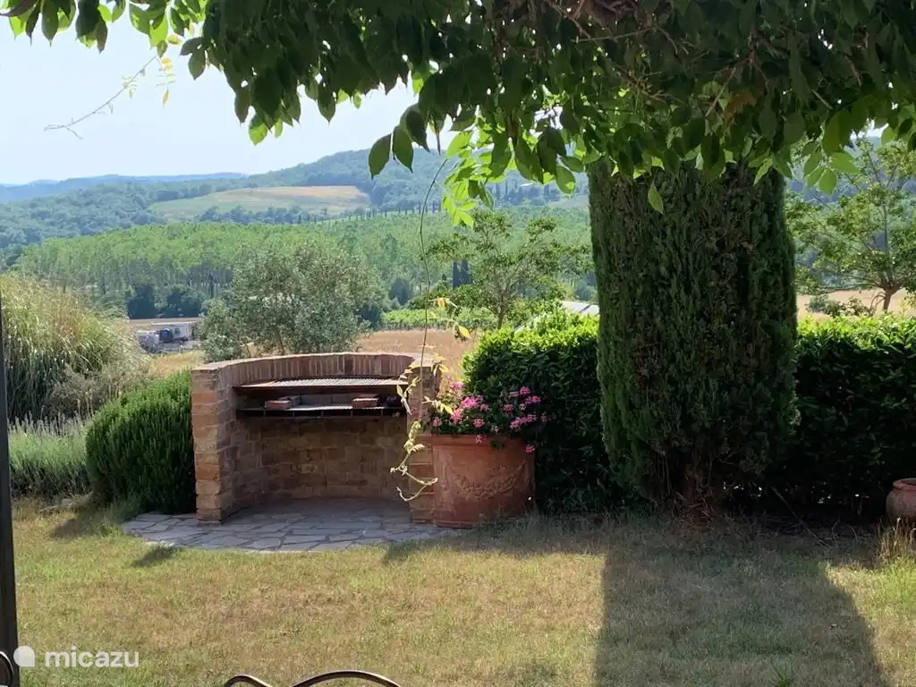 Una barbacoa de piedra en el jardín con unas vistas estupendas mientras se hace una barbacoa.