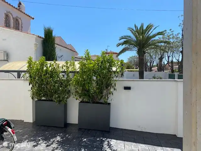 vakantiehuis huren in Spanje, Costa Brava, Empuriabrava – 6 persoons Villa Het zijterras is te gebruiken als afgesloten parkeerplaats voor de auto, maar ook als een ligplaats voor 2 zonnebedden. Gezellig aangekleed met mooie plantenbakken.