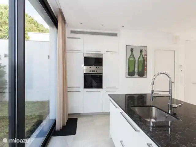 vakantiehuis huren in Spanje, Costa Brava, Empuriabrava – 6 persoons Villa Achterzijde keuken met een schuifpui naar het achterterras. Op dit terras staat een buitentafel met 6 tuinstoelen. Tevens een hangmat om heerlijk in de schaduw uit te rusten, lezen of siësta houden..