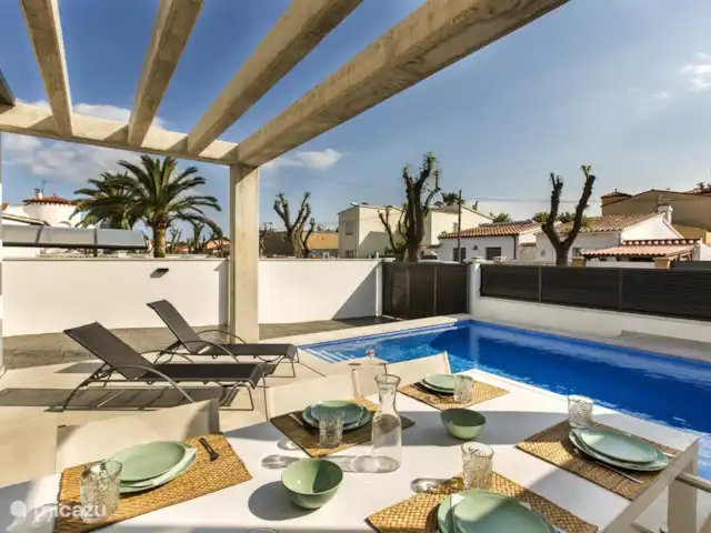 vakantiehuis huren in Spanje, Costa Brava, Empuriabrava – 6 persoons Villa Heerlijk terras voorzien van 4 ligbedden. Ligbedden worden ook aan de zijkant van het huis geplaatst. Terras is voorzien van een 2de tuintafel met 6 terrasstoelen en een parasol.