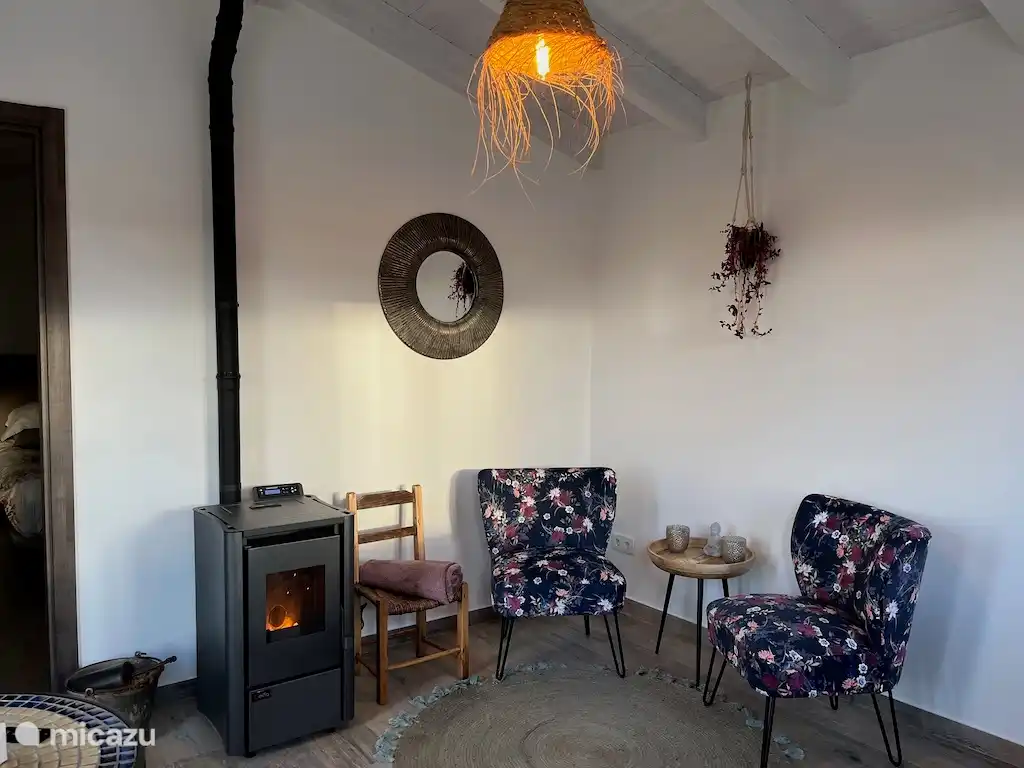 Gemütliches Wohnzimmer mit Blick auf den Garten und die Landschaft. Pelletofen für die Wintermonate.