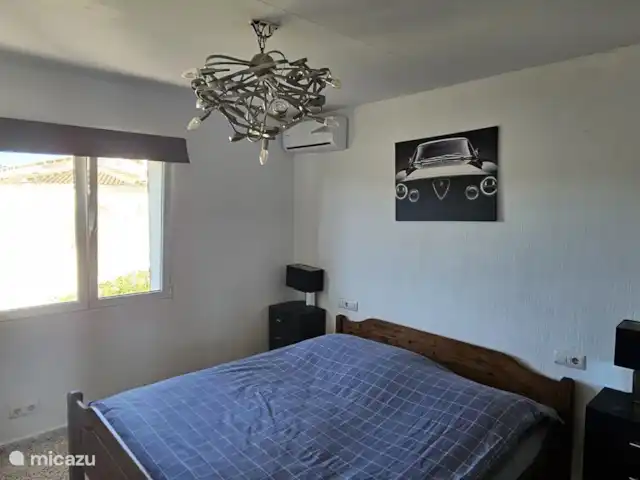 Casa Yavari en España, Costa Blanca, Pedreguer  - villa Dormitorio 1 en Casa Yavari
Amplio dormitorio con aire acondicionado, TV vía satélite, una cómoda cama doble y un armario empotrado con preciosas puertas de madera tallada valenciana. Disfruta de la vista del jardín a través de la ventana.