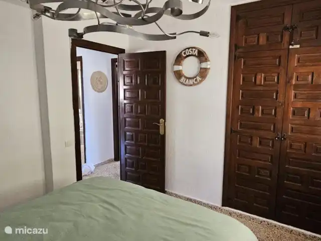 Casa Yavari en España, Costa Blanca, Pedreguer  - villa Dormitorio 2 en Casa Yavari
Atractivo dormitorio con aire acondicionado, cama doble, armario empotrado con puertas de madera tallada valenciana y vista a la primera pérgola ibicenca junto a la puerta principal. Equipado con mosquitera y reja frente a la ventana.