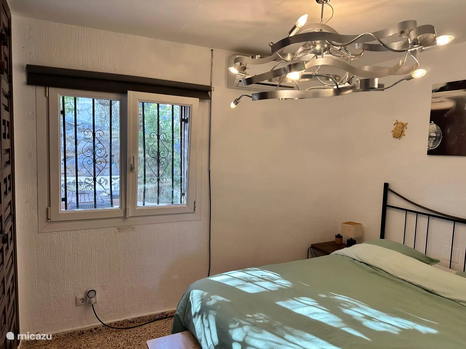 Schlafzimmer neben Klimaanlage auch Moskitonetz vor dem Fenster, mit Aussichtsgarten.