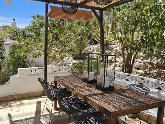 Casa Yavari en España, Costa Blanca, Pedreguer  - villa Pérgola ibicenca en Casa Yavari
Acogedora pérgola con techo de paja, lámparas de mimbre negro y mesa de roble junto a la puerta de entrada. Ideal para desayunar, almorzar o hacer una barbacoa, con mucha privacidad y rodeado de exuberantes plantas.