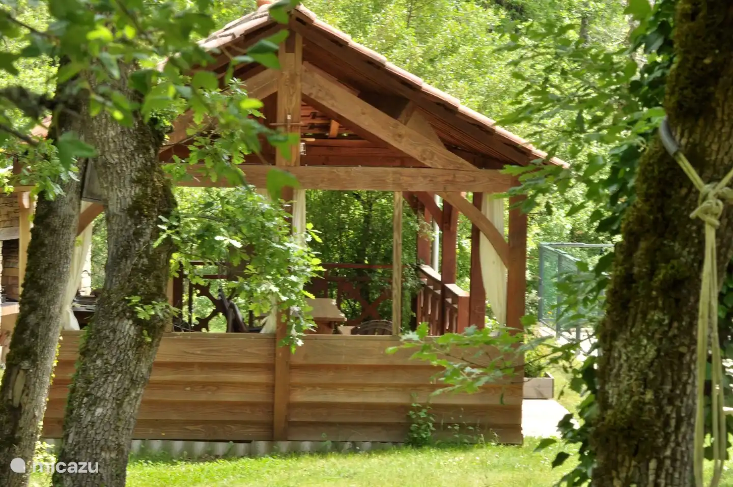terraza de la piscina cubierta con sillas, mesas, cocineta y barbacoa al lado