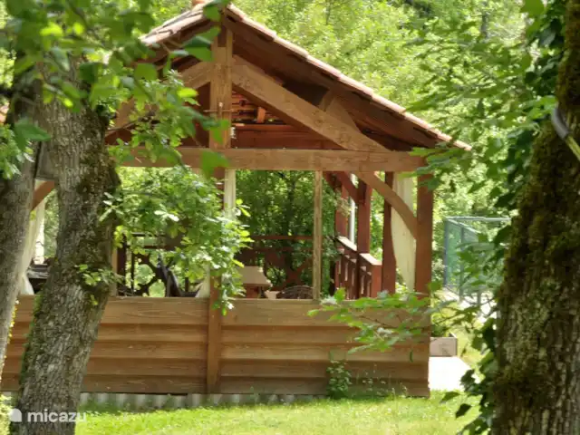 Le nid de l'écureuil en Francia, Lot, Lavercantière - chalet terraza de la piscina cubierta con sillas, mesas, cocineta y barbacoa al lado