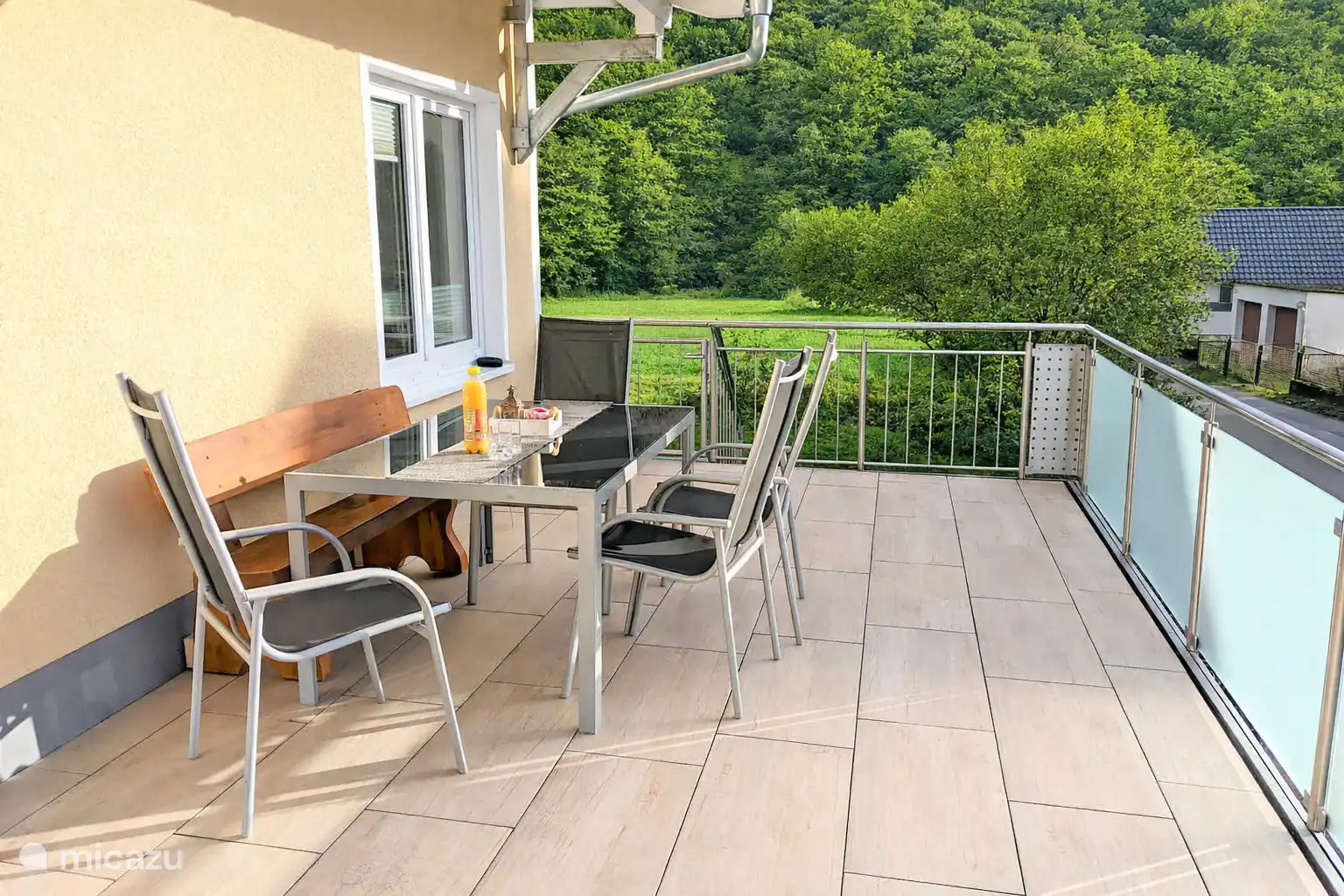 Het terras kijkt uit over het bos en kijkt naar het zuiden naar de zon.