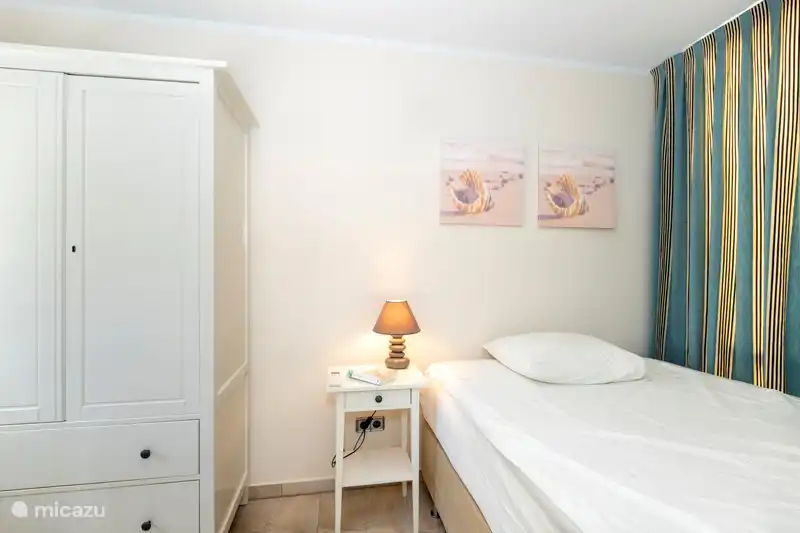 Bedroom on the ground floor with a 140 bed, wardrobe and a sink.