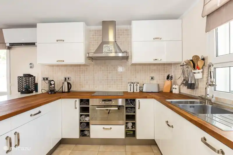 A generously equipped kitchen with a large fridge-freezer, sufficient kitchen utensils, oven-microwave, toaster and a Nespresso machine