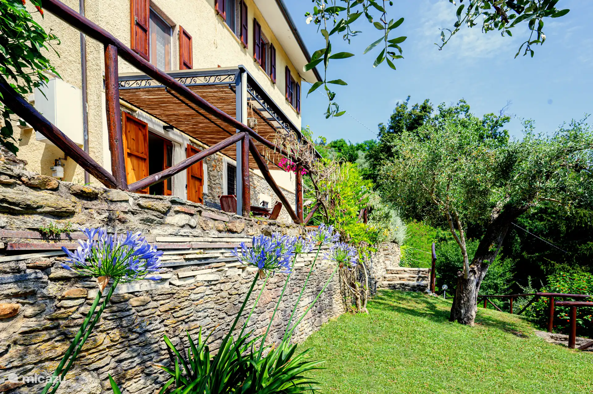Gran jardín con una valla bien cuidada y hermosos jardines.