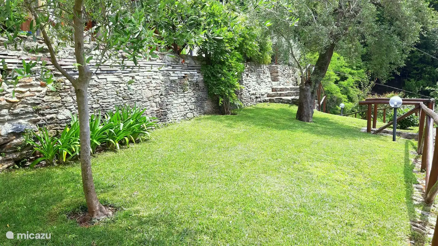 Gran jardín con una valla bien cuidada y hermosos jardines.
