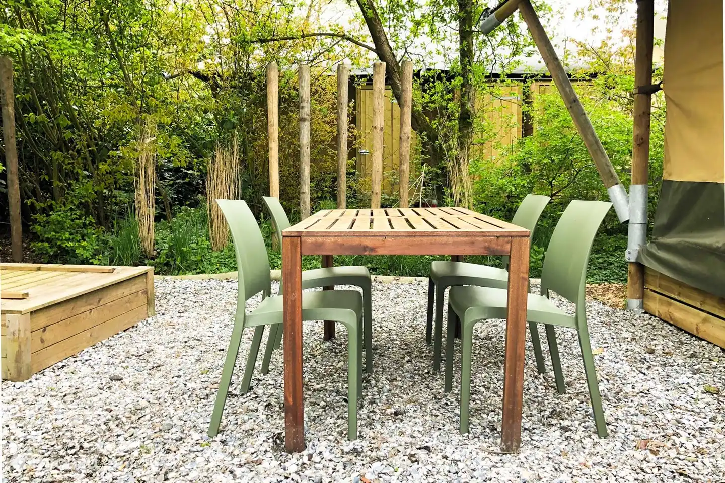 In de beschutte achetertuin is een eetstel en Weber Bbq