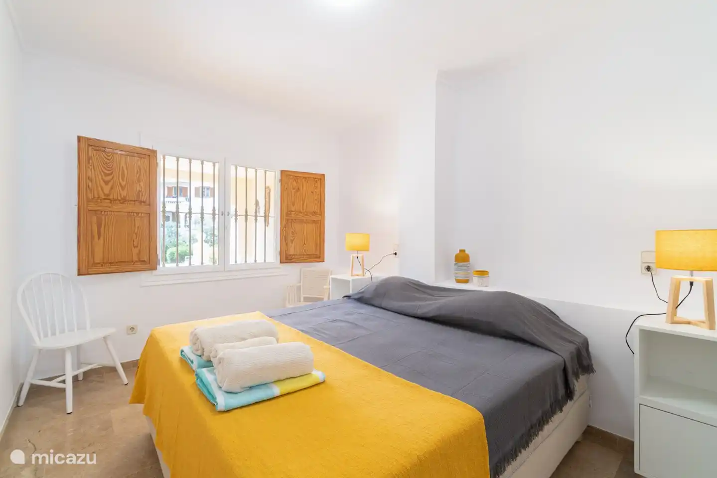 Hauptschlafzimmer mit 180x200 Bett und Blick auf die Rückseite des Komplexes.