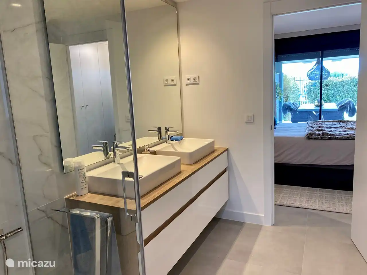 Doorkijk van de badkamer, via de slaapkamer naar de tuin
