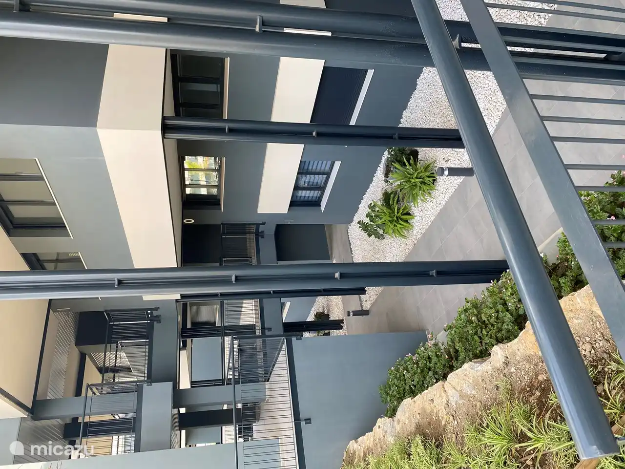 Een doorkijkje vanaf het centrale binnenplein waar ook het zwembad is. Ons appartement ligt 1 verdieping lager waar de tuinen zijn.