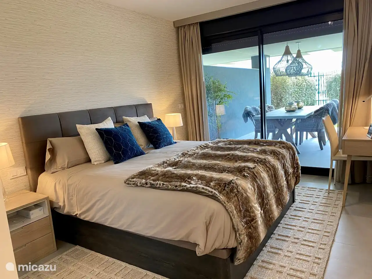 De 1e slaapkamer heeft een groot bed met een kap-/ werktafel en stoel. In de nachtkastjes zit een usb oplader met (IPhone)snoer en nachtverlichting