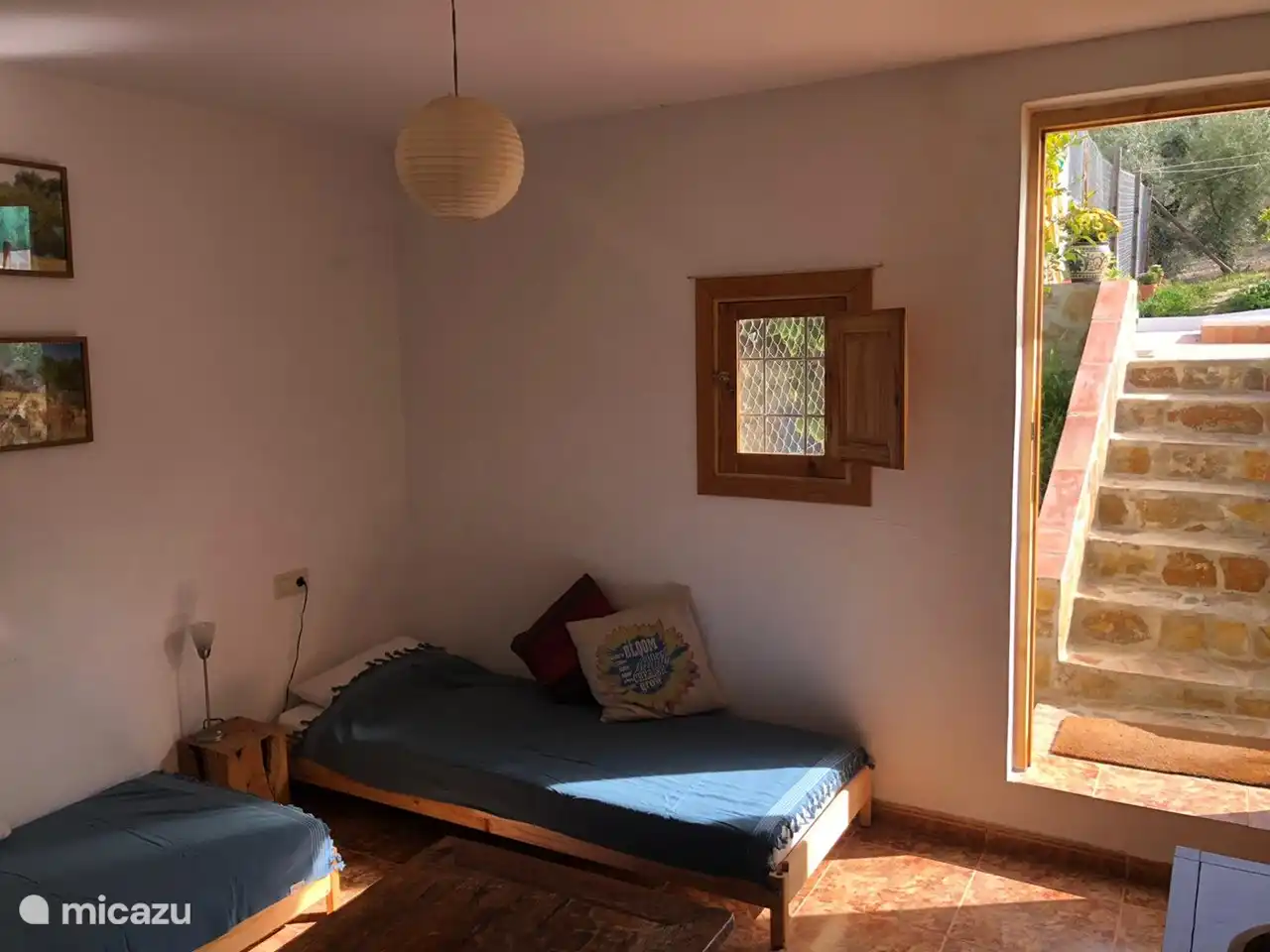 Gartenzimmer mit Tür zur Terrasse mit Swimmingpool.