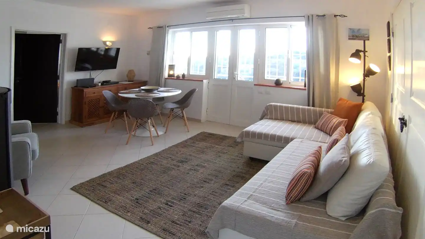 Das geräumige Wohnzimmer mit Esstisch, Sofa / Sofa, Sessel und Ofen