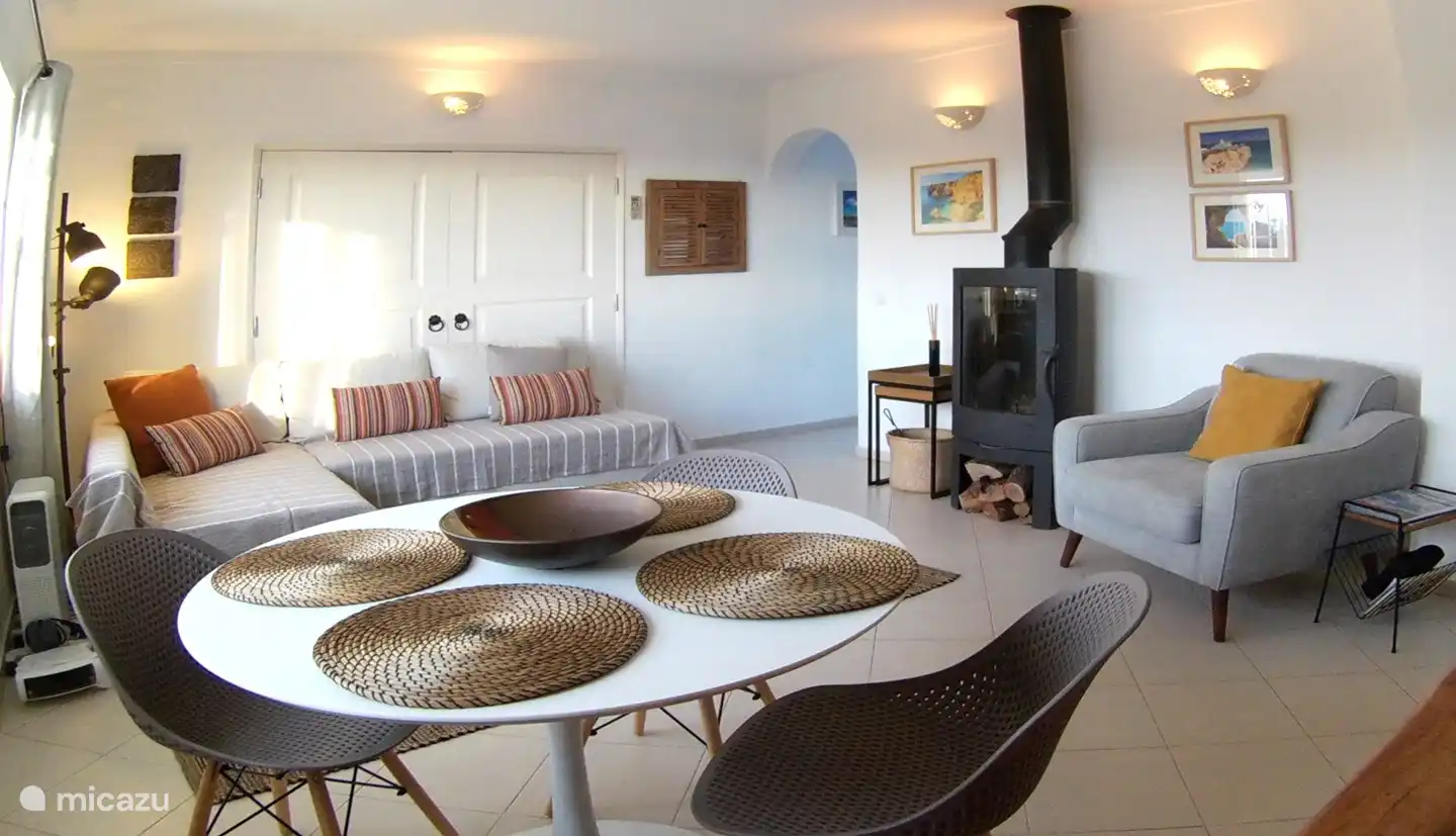 Das geräumige Wohnzimmer mit Esstisch, Sofa / Sofa, Sessel und Ofen