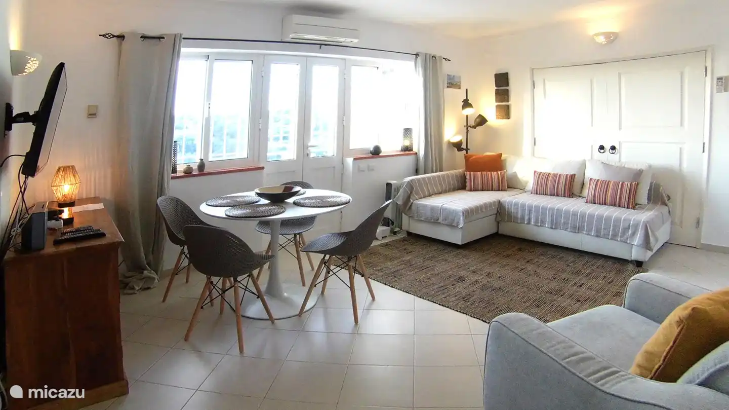 Das geräumige Wohnzimmer mit Esstisch, Sofa / Sofa, Sessel und Ofen