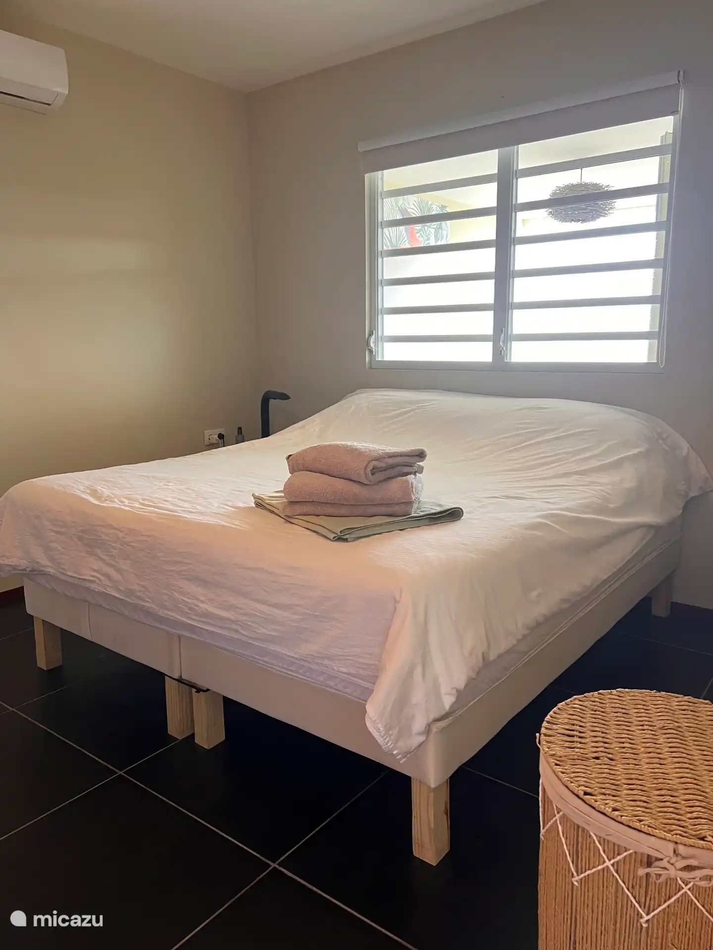 Chambre principale (180x200) avec climatisation et grandes armoires encastrées, adjacente à la salle de bain principale.