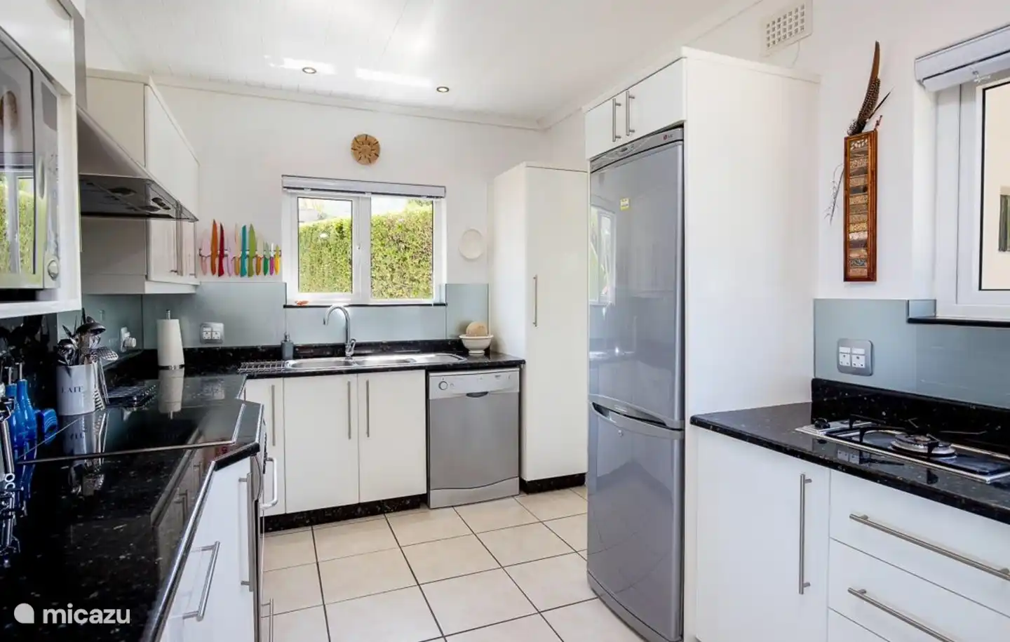 Es gibt eine Tür zur Waschküche, wo sich eine Waschmaschine und ein Trockner befinden.