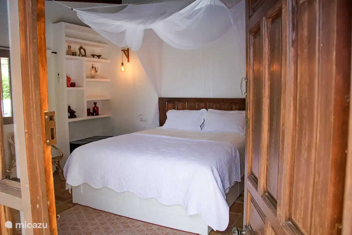 Chambre 1 avec un lit double et accès direct au jardin.