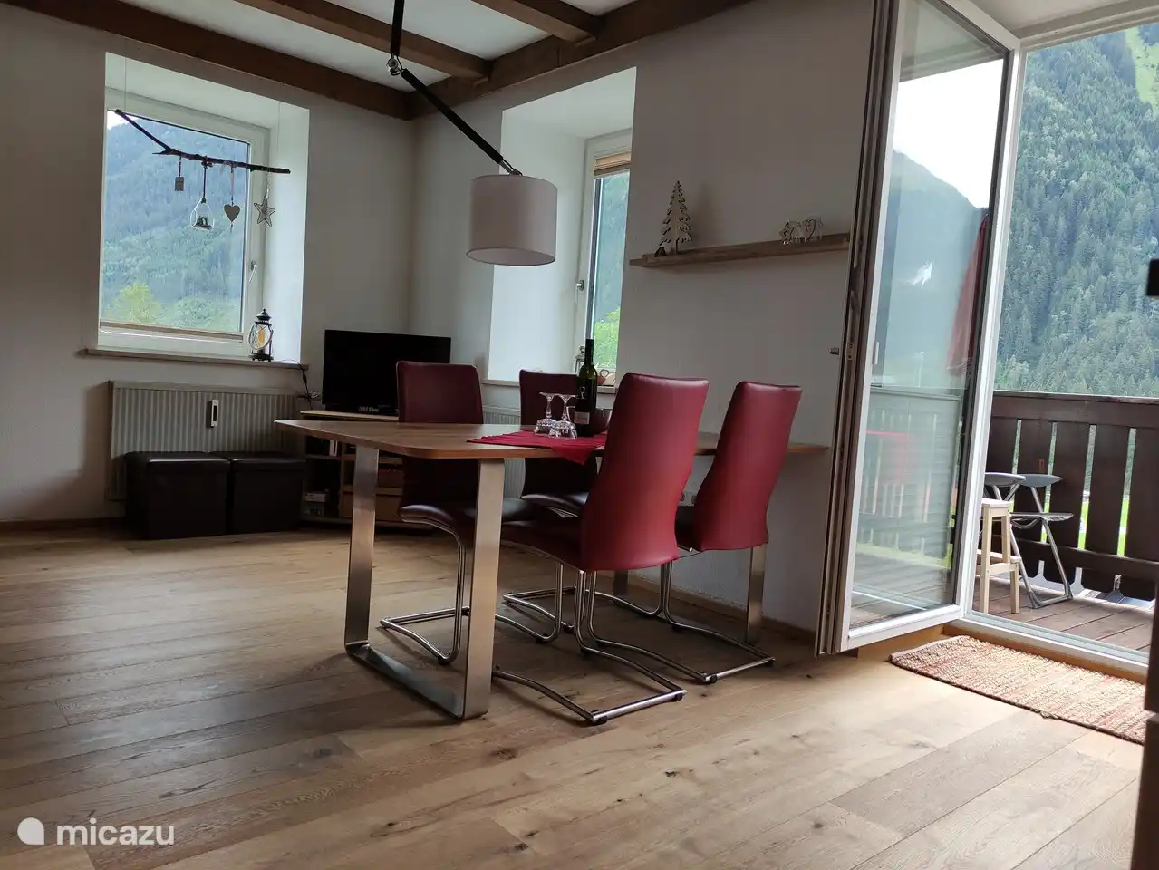 Geräumiges helles Wohnzimmer mit Zugang zum Balkon. Holzlaminat im Zimmer.