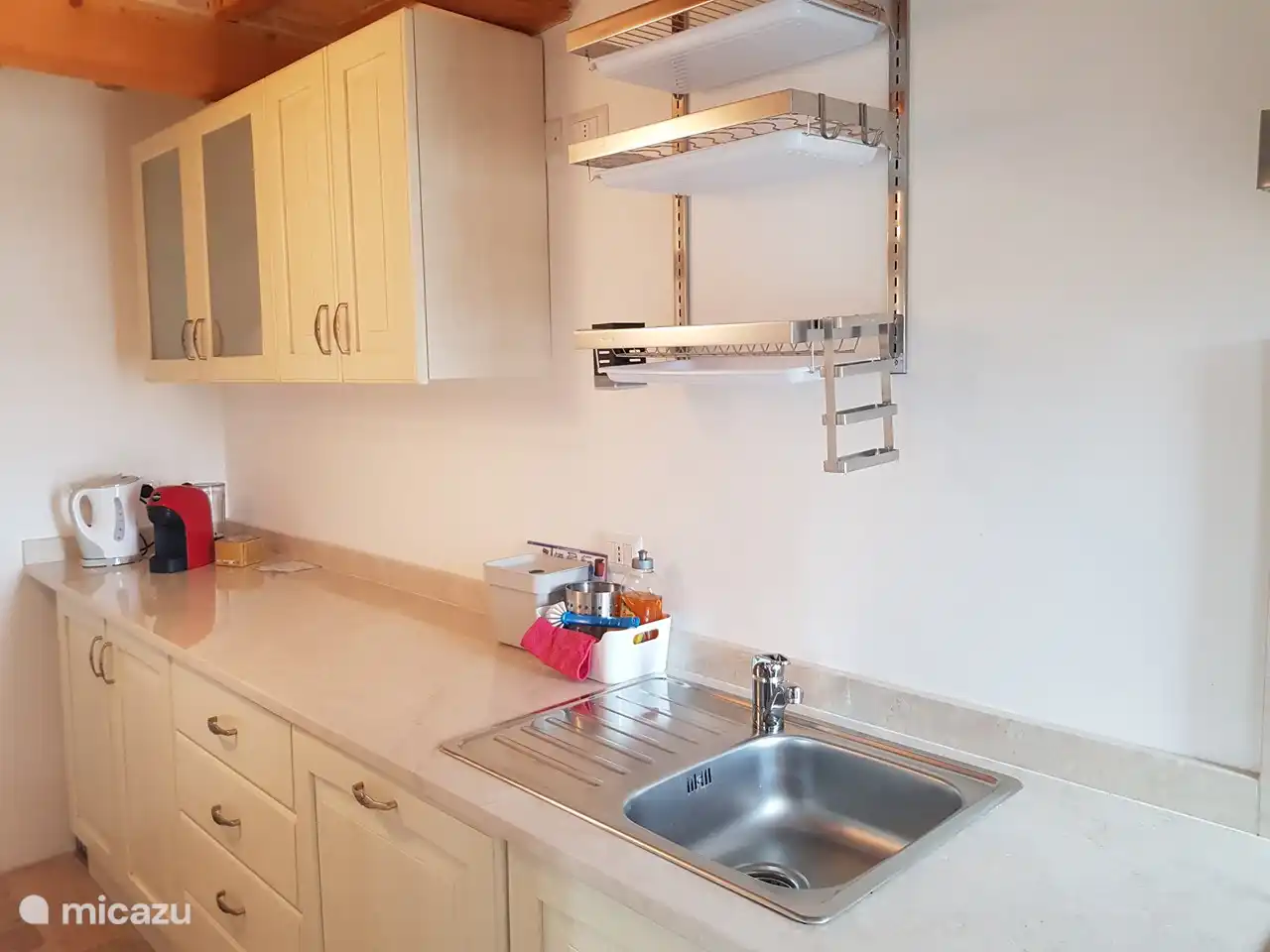 Cocina con nevera grande y congelador, vitrocerámica de gas, lavavajillas, horno, cafetera, tetera y utensilios de cocina