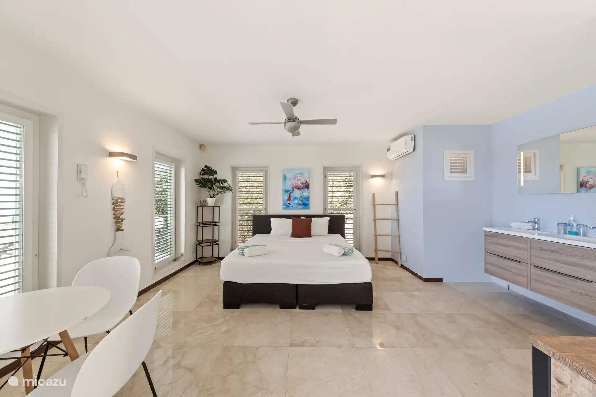 Geräumiges zweites Schlafzimmer mit eigenem Waschbecken und Sitzgelegenheiten.