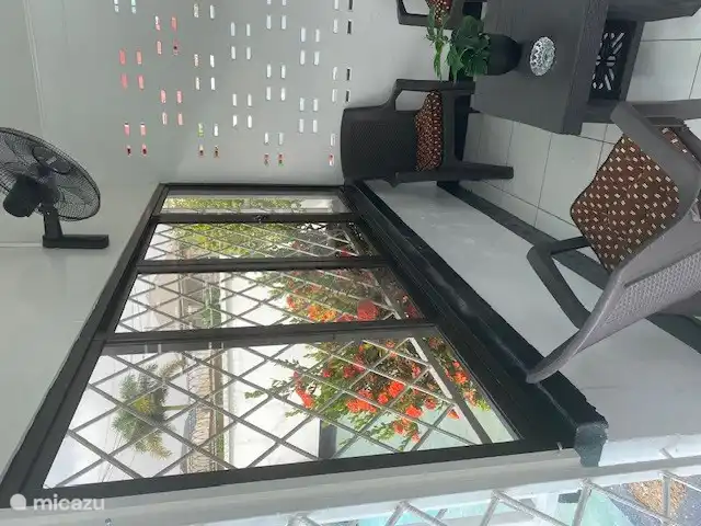 balcony with partially sliding windows and fan with remote control on the wall in 2024