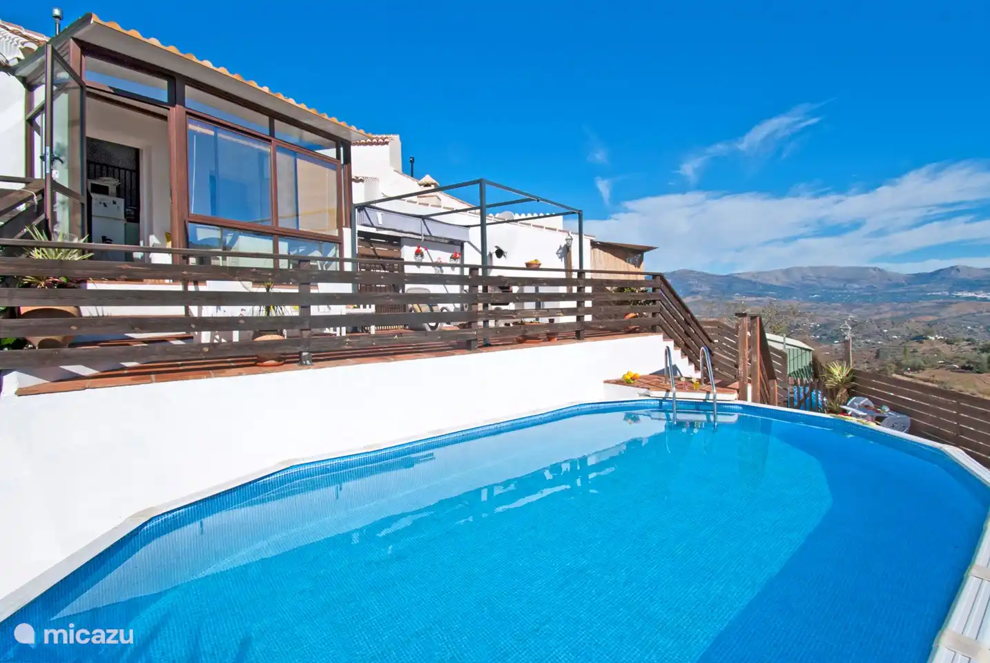 Von der Terrasse aus können Sie den Blick auf das Schwimmbad und die umliegenden Berge genießen.