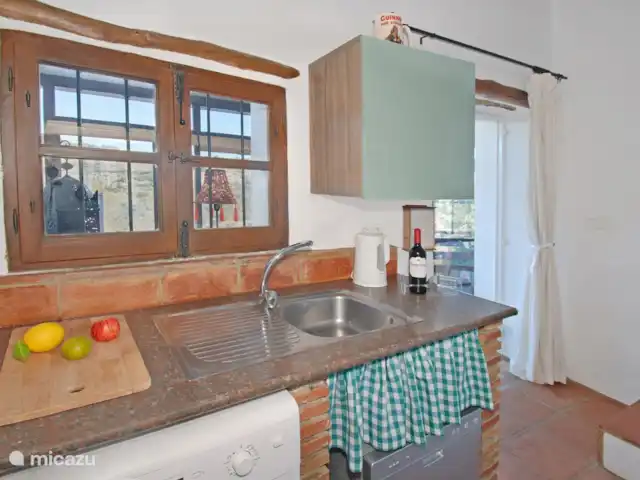 casa rural / cabaña en España, Costa del Sol, Comares – Casita Martín Salga de la terraza a una cocina pequeña pero muy bien equipada, donde cada detalle ha sido diseñado para brindar eficiencia y funcionalidad.