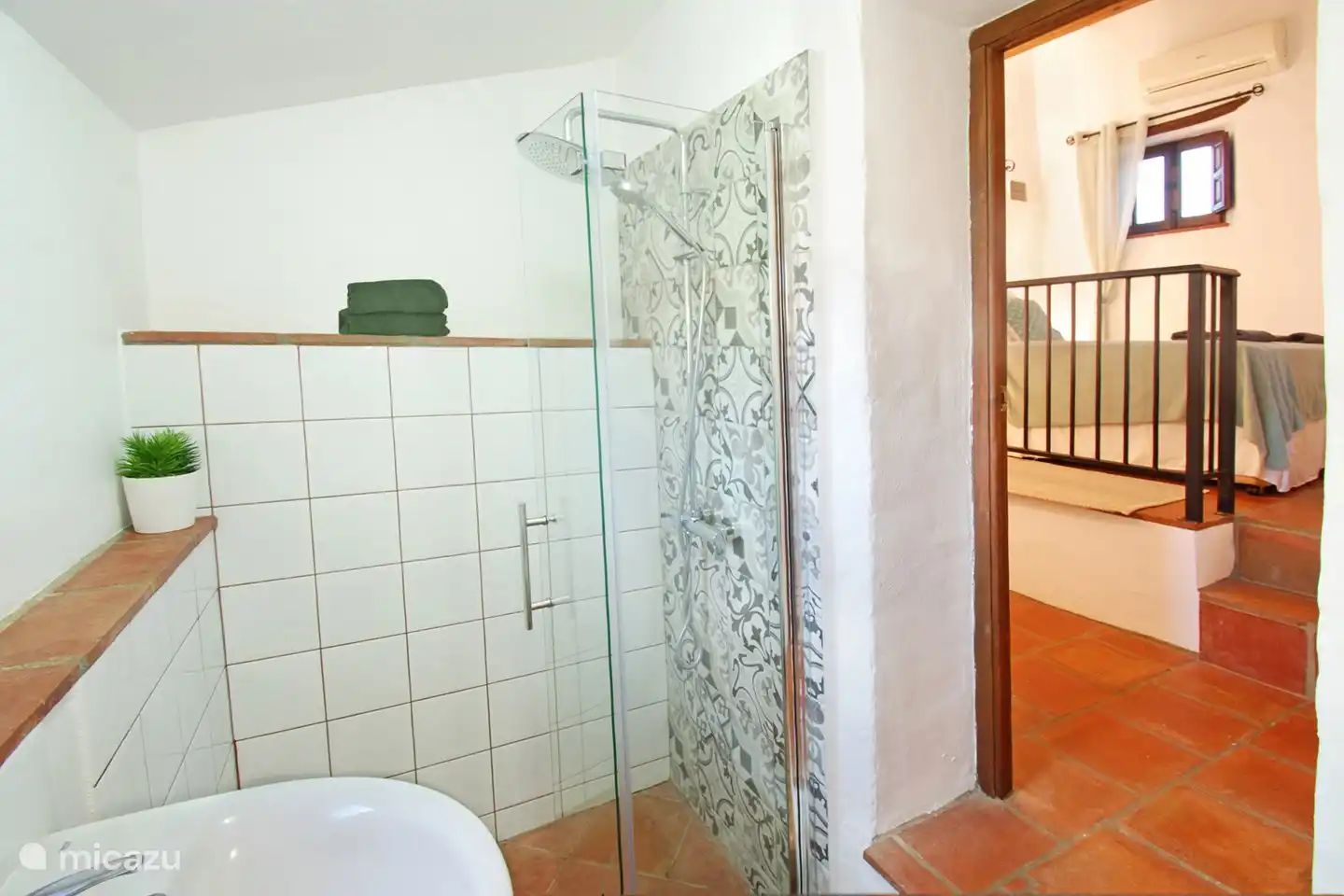 Betreten Sie das geräumige Badezimmer, in dem Sie eine ebenerdige Dusche finden.