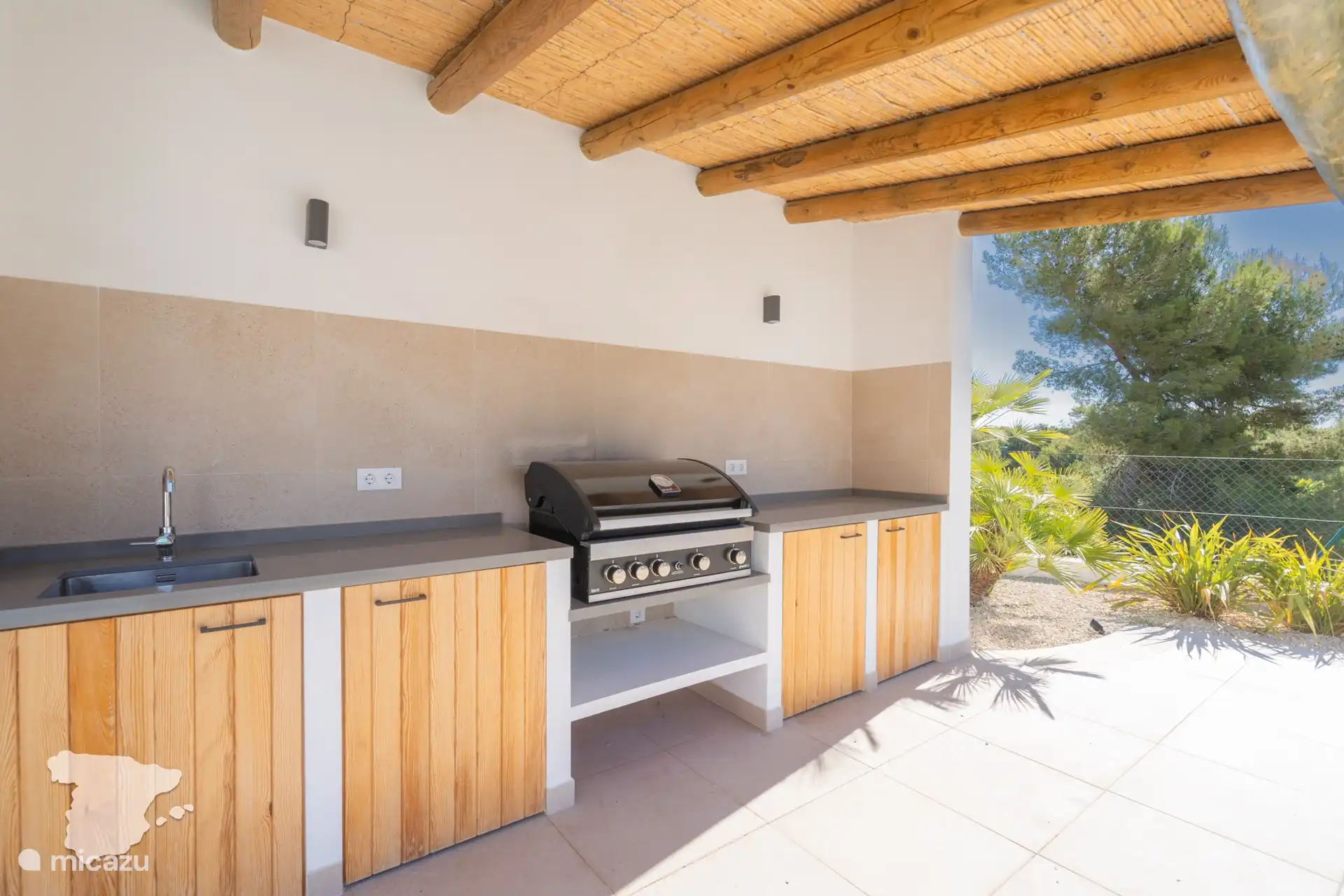 Cocina exterior con barbacoa de gas.