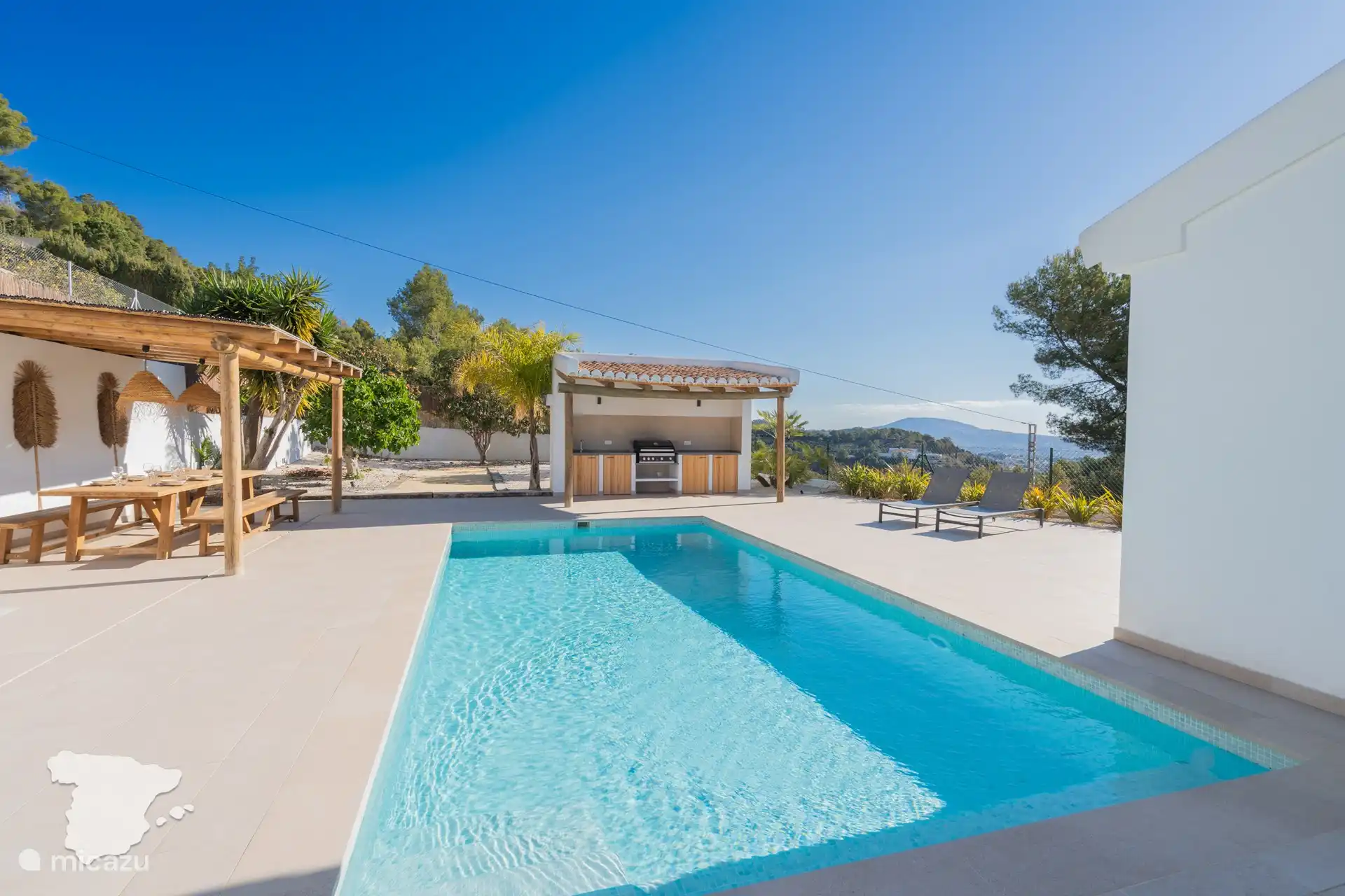 Piscina, comedor cubierto y cocina al aire libre.