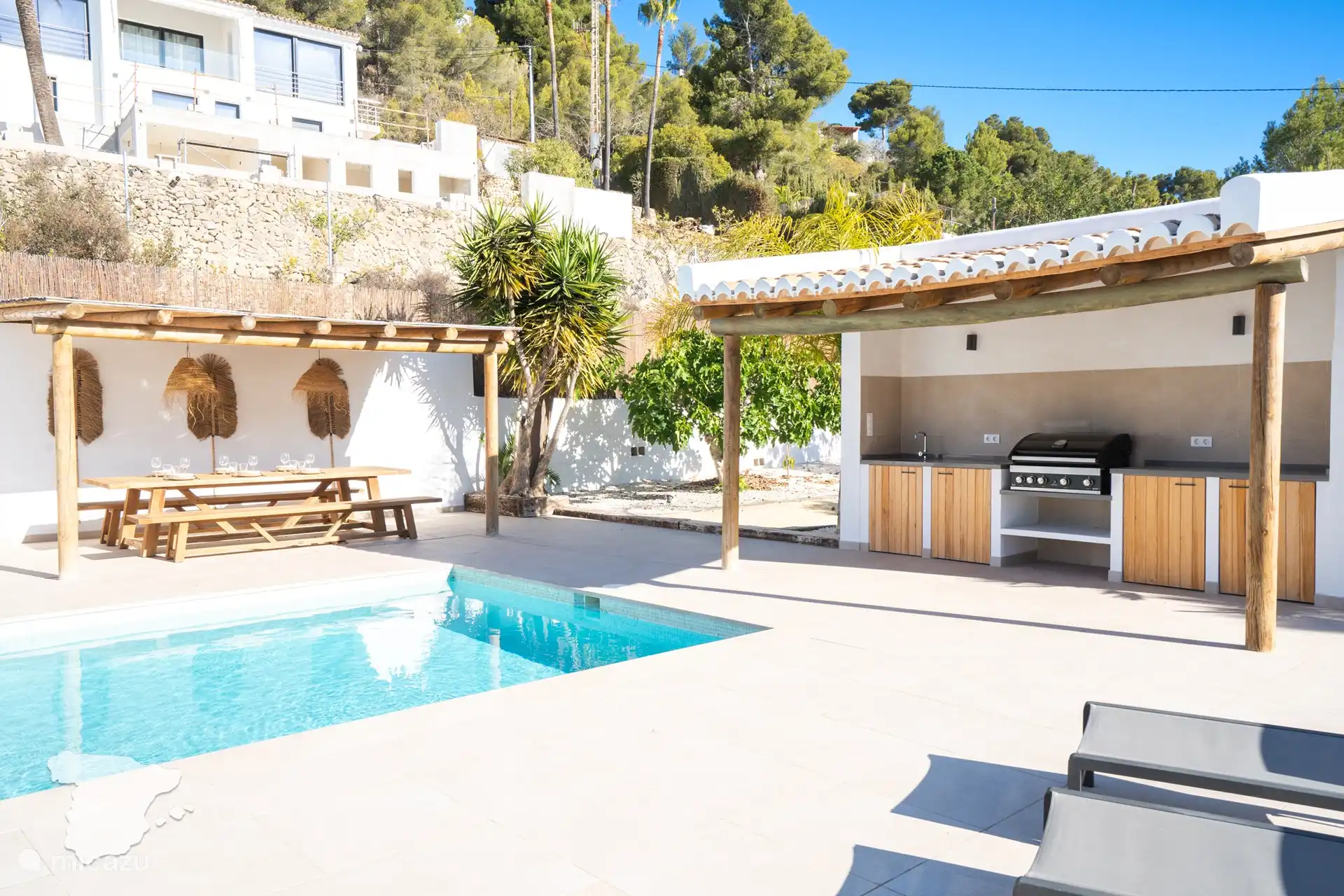 Piscina, comedor cubierto y cocina al aire libre.