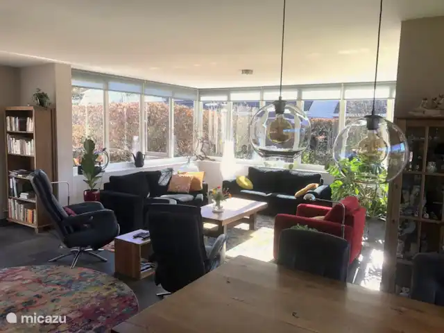 bungalow huren in Nederland, Drenthe, Zeijen – Vrijstaande bungalow met grote tuin Sfeervolle woonkamer met zithoek. Rondom aan drie zijden glas met veel licht.