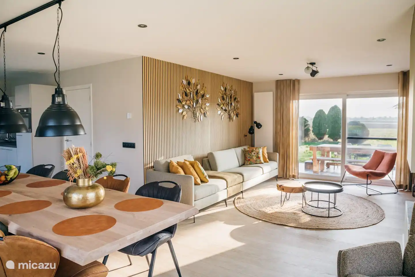 Sfeervolle woonkamer met open haard en openslaande tuindeuren en een grote zithoek voorzien van een Smart TV.